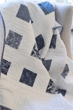 a blue and white quilt sitting on top of a couch