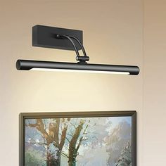 a painting is hanging on the wall next to a light that has been turned on