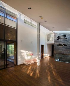 the inside of a house with wood floors and glass doors on either side of it