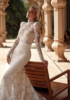 a woman in a wedding dress sitting on a bench