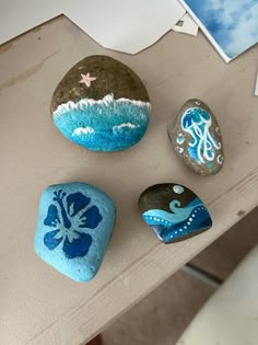 three painted rocks sitting on top of a table