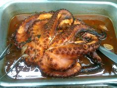 an octopus is being cooked in oil with a knife