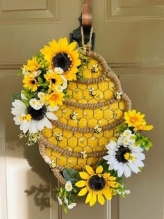 sunflowers and daisies are arranged in a basket hanging on the front door