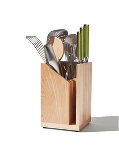 a wooden holder with utensils and spoons in it