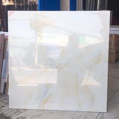 a large white marble slab sitting on top of a cement floor next to a pile of boxes