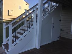 a white stair case next to an open door on a house's front porch