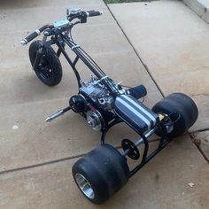 a small motorcycle is parked on the side of the road with its engine attached to it's front wheel