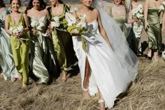 a group of women standing next to each other on top of a dry grass field