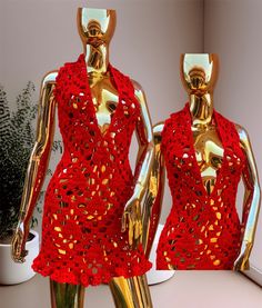 two gold mannequins with red dresses on display