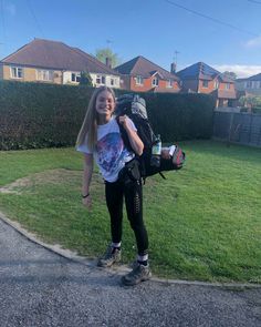 a girl with a backpack is standing in the street