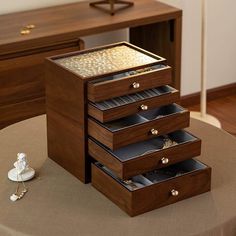 a wooden jewelry box sitting on top of a table