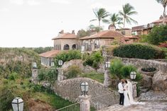 a bride and groom standing on a stone bridge