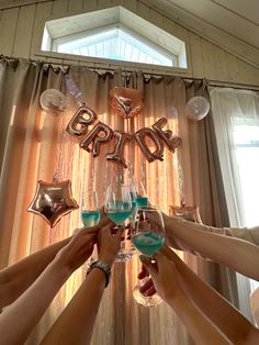 several people toasting with blue liquid in front of balloons