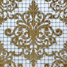 a white and gold tiled wall with an intricate design