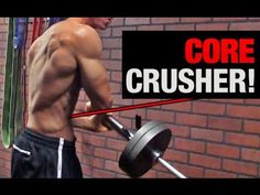 a man holding a barbell in front of a brick wall with the words core crusher