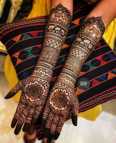 two hands with henna designs on them