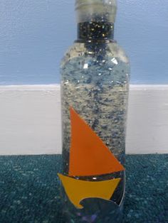 a glass bottle with an orange sail on it