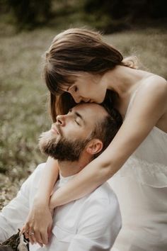 a man and woman are sitting in the grass