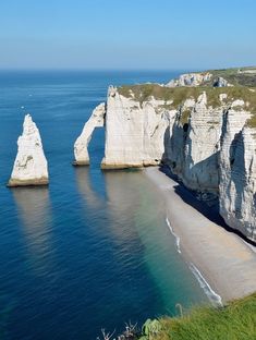 the beach is next to some tall white cliffs