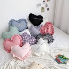 several heart shaped pillows on top of a bed