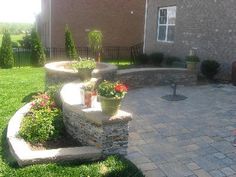 a brick patio with potted plants in the middle