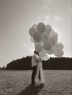 black and white photo of couple kissing with balloons