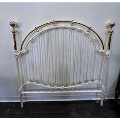 a white headboard with two brass posts