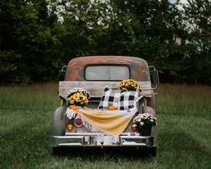 an old pick up truck decorated with flowers and blankets