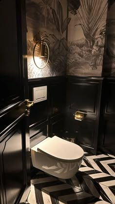 a black and white bathroom with a toilet in the corner, wallpaper on the walls