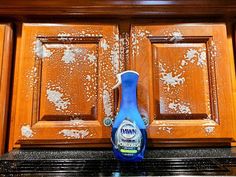 a spray bottle sitting on top of a counter in front of a wooden cabinet door