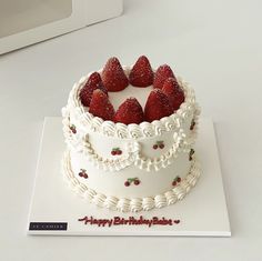 a birthday cake with strawberries on top