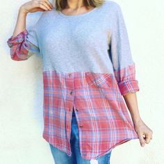 a woman standing in front of a white wall with her hand on her hip and looking at the camera