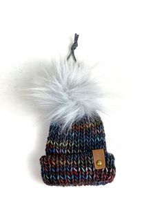 a knitted hat with a fur pom - pom on top of it