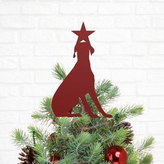 a red dog sitting on top of a christmas tree