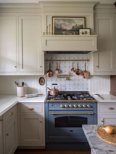 a kitchen with an oven, stove and counter tops in white painted wood paneling