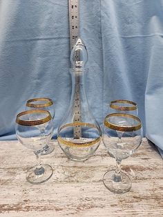 three wine glasses sitting on top of a wooden table next to a measuring tape measure