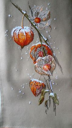 an embroidered piece of cloth with flowers and leaves on it, hanging from a twig