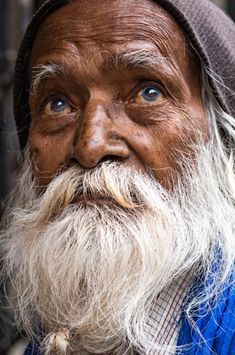 an old man with long white beard and blue shirt