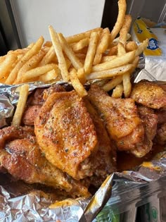 chicken wings and french fries on tin foil