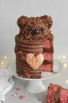 a teddy bear made out of chocolate cake on a plate with a slice cut out