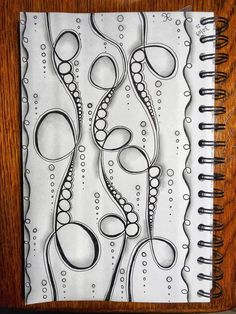 a spiral notebook with some black and white designs on it