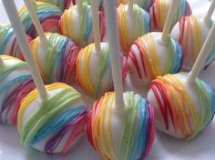 there are many candy lollipops with different colors on them and white sticks sticking out of them