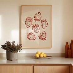 a bowl of lemons and strawberries on a kitchen counter with a framed strawberry print