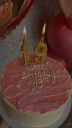 a birthday cake with pink frosting and candles