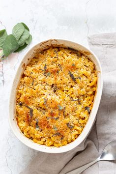 a casserole dish filled with macaroni and cheese on top of a table