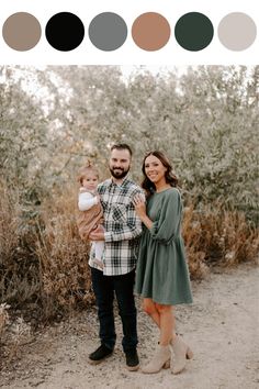 a man and woman holding a baby standing in front of some bushes with the color scheme