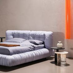 a white couch sitting next to a table with an orange vase on top of it