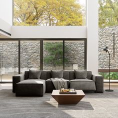 a modern living room with stone walls and large windows