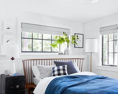 a bedroom with white walls and blue bedding