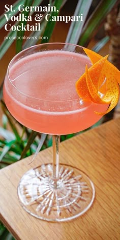 a pink cocktail with an orange garnish on the rim